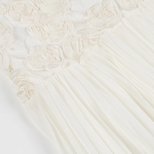 Detail of 3D rose floral appliqué and pleated chiffon hem on elegant white spring dress