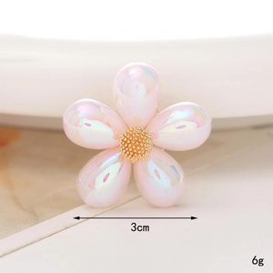 Detail view of 3cm iridescent pink flower charm for shoes with golden center accents