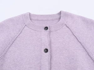 Detail view of lavender knit cardigan showing soft texture and black round buttons
