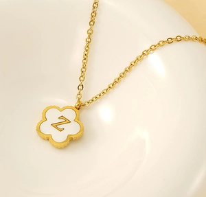 Detailed view of golden Z-letter pendant with white clover inlay on fine chain