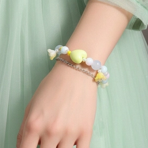 Detalle de una pulsera de doble capa con corazones de resina amarillos y cuentas de cristal