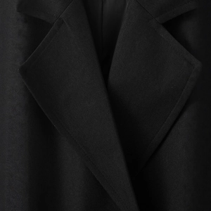 Close-up of black textured twill coat collar with premium tailoring and minimalist style