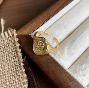 Detailed view of vintage gold sunflower relief open ring in a wooden jewelry box