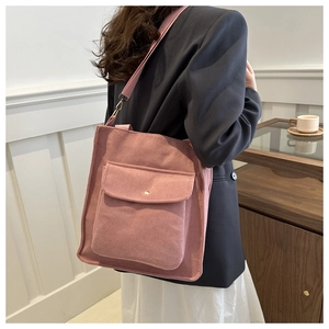 Pink corduroy tote bag detail showing the front flap pocket and soft ribbed texture