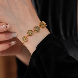 Close-up of vintage flower bracelet with olive green zircon petals and gold adjustable chain