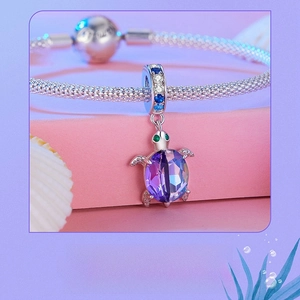 Macro shot of 925 sterling silver sea turtle charm with purple and blue gradient gemstone