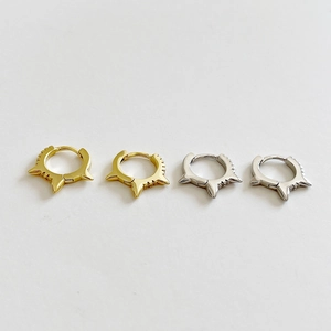 Detail of spiked S925 sterling silver hoop earrings in gold and silver finishes