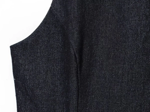 Close-up of premium dark denim fabric texture with detailed stitching and twill weave