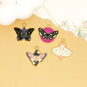 Detailed close-up of four black and purple enamel butterfly and moth charms with gold trim