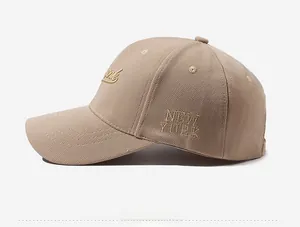 Detailed side view showing gold New York embroidery on beige canvas baseball cap