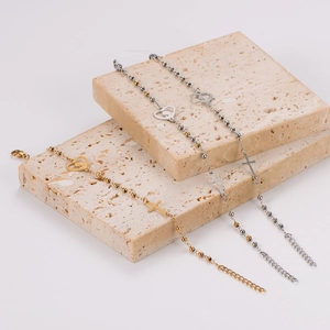 Minimalist stainless steel ball chain bracelet with heart and cross charms on stone