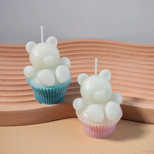 Vue détaillée de bougies oursons 3D en moules muffins bleu et rose sur étagère