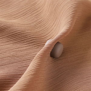 Brown ribbed knit fabric close-up featuring a matte round magnetic silk scarf buckle