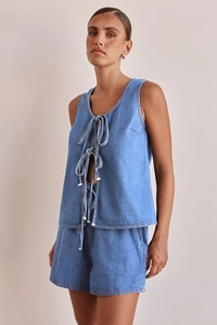 Detalle de los cordones en el top de mezclilla azul oscuro y los pantalones cortos a juego
