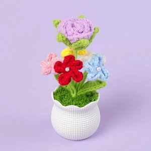 Detail of handmade crochet purple rose potted plant with pearl accents in a white vase