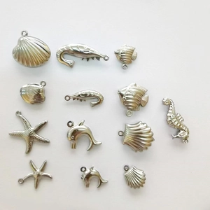 Detailed collection of stainless steel ocean pendants featuring shells, starfish, and dolphins