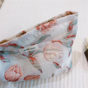 Détail du tissu jacquard à tulipes et étiquette sur la trousse de maquillage