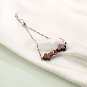 Detail of adjustable stainless steel chain bracelet with red cross agate beads on silk