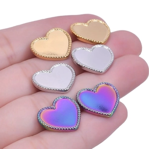 Close-up of heart-shaped stainless steel earring studs in gold, silver, and rainbow tones