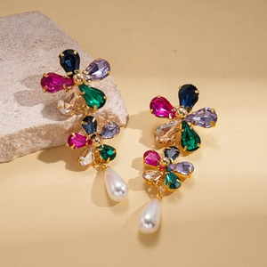 Macro detail of 18k gold floral earrings with multicolor crystals and drop pearls