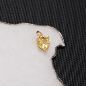 Macro shot of gold-plated heart pendant with a brilliant yellow zircon stone