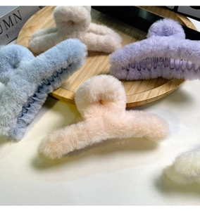 Détail des grandes pinces à cheveux en peluche de 14cm en beige, bleu clair, violet et crème