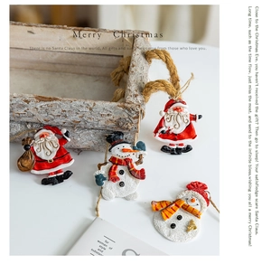Detail of resin Santa and snowman ornaments in a vintage wooden box on a white base