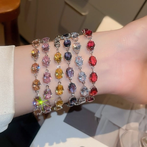 Close-up of sparkling oval zircon bracelets in multiple colors on a model's wrist