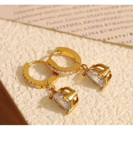Détail de boucles d'oreilles dorées avec micro-zircons et pendentifs en cristal translucide