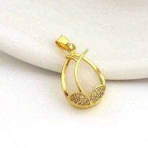 Macro shot of 18k gold tulip pendant with white teardrop stone and zircon accents
