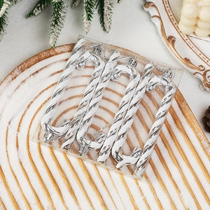 Detail of silver spiral candy cane Christmas ornaments in a gift box with snowy decor