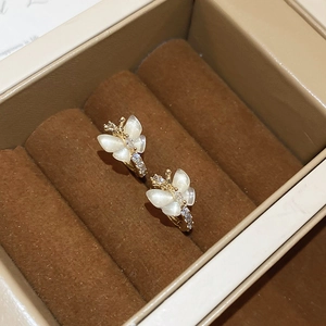 Gros plan boucles d'oreilles papillon dorées avec ailes en opale et zircons blancs