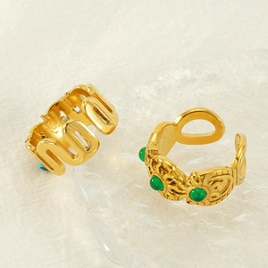 Vintage gold stainless steel rings with malachite inlay on textured glass tray