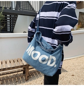 Outdoor shot showing back of model wearing denim tote bag with white MOOD text print
