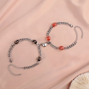 Luminous heart magnetic bracelets on pink silk background with silver cuban link chain