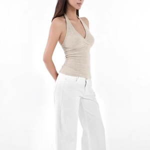 Detailed texture of the beige ribbed knit fabric on a slim fit halter neck top