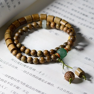 Detail of wooden beaded bracelets with lotus carving on a book background with soft lighting