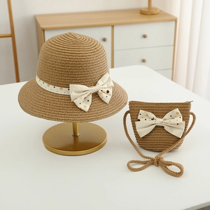 Detail of children's straw hat and matching bag set with polka dot bow decoration