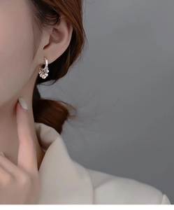 Detail of 925 sterling silver hoop earrings featuring multiple dangling small silver beads