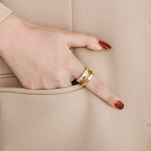 Detail of a gold multi-layer ring with Roman numerals and sparkling cubic zirconia