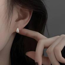 Close-up of minimalist S925 sterling silver small hoop earring worn by a model