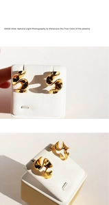 Detailed macro shot of twisted wave earrings with polished golden metallic finish