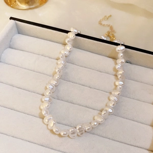 Vue détaillée du collier de perles irrégulières blanches avec fermoir doré chic