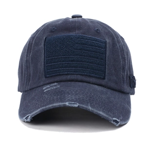 Detail of navy blue washed baseball cap featuring USA flag patch and vintage distressed edges