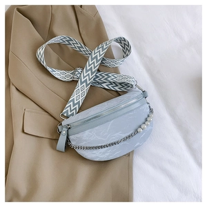 Detail der hellblauen Tasche mit Marmormuster, Perlenkette und gewelltem Schultergurt