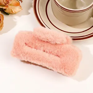 Large pink plush hair claw clip with soft faux fur detail on a cozy aesthetic background