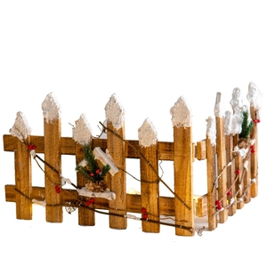 Wooden Christmas tree fence with white snow, pine cones and warm LED lights