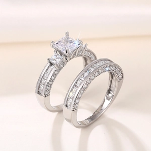 Detail van een princess cut verlovingsring en een pavé diamanten trouwring van zilver