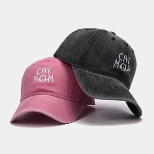 Detail of pink and grey cotton baseball caps with CAT MOM embroidery and vintage texture