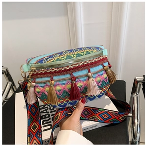 Macro detail of bohemian crossbody bag with ethnic patterns and colorful fringe tassels